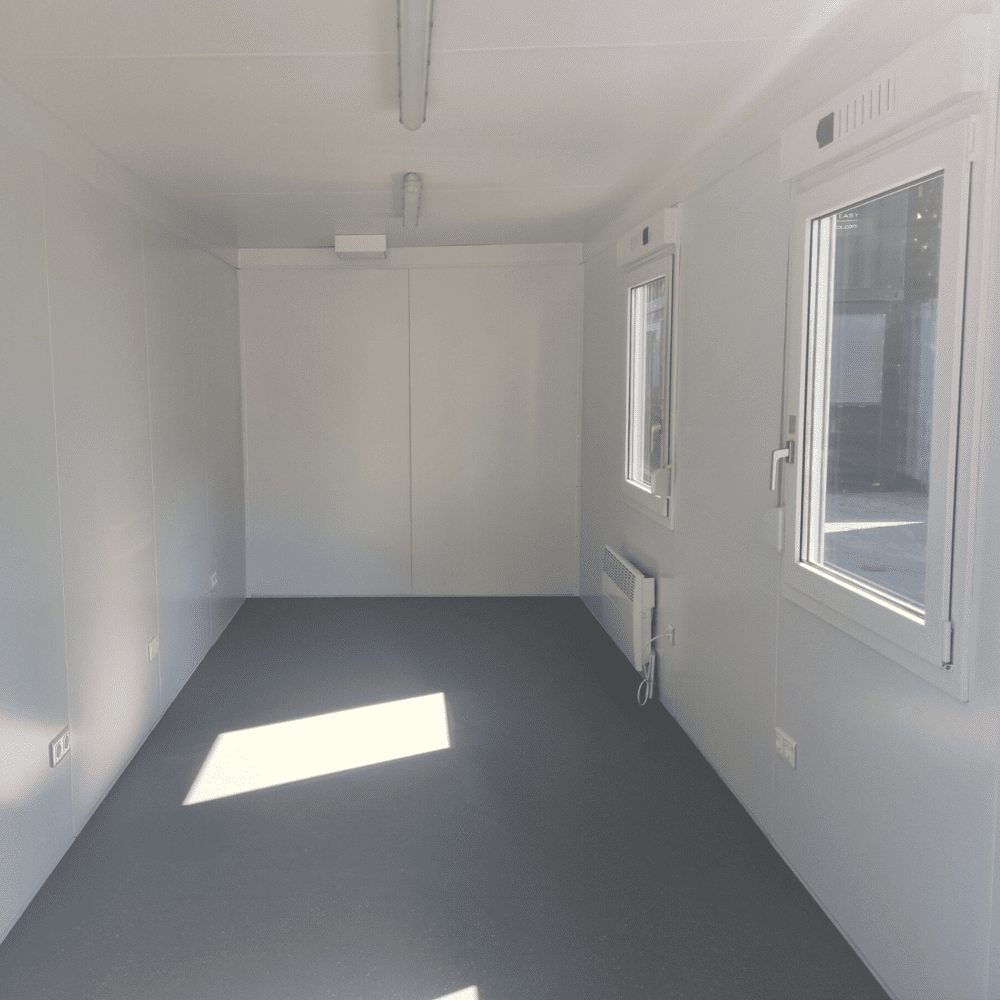 Kontorscontainer sk kontorsbod i grått med två fönster interiör