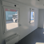 Kontorscontainer sk kontorsbod i grått med två fönster interiör