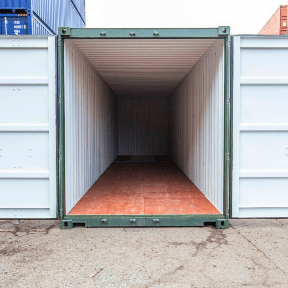 Grön container 40 fot med öppna dörrar i containerdepå