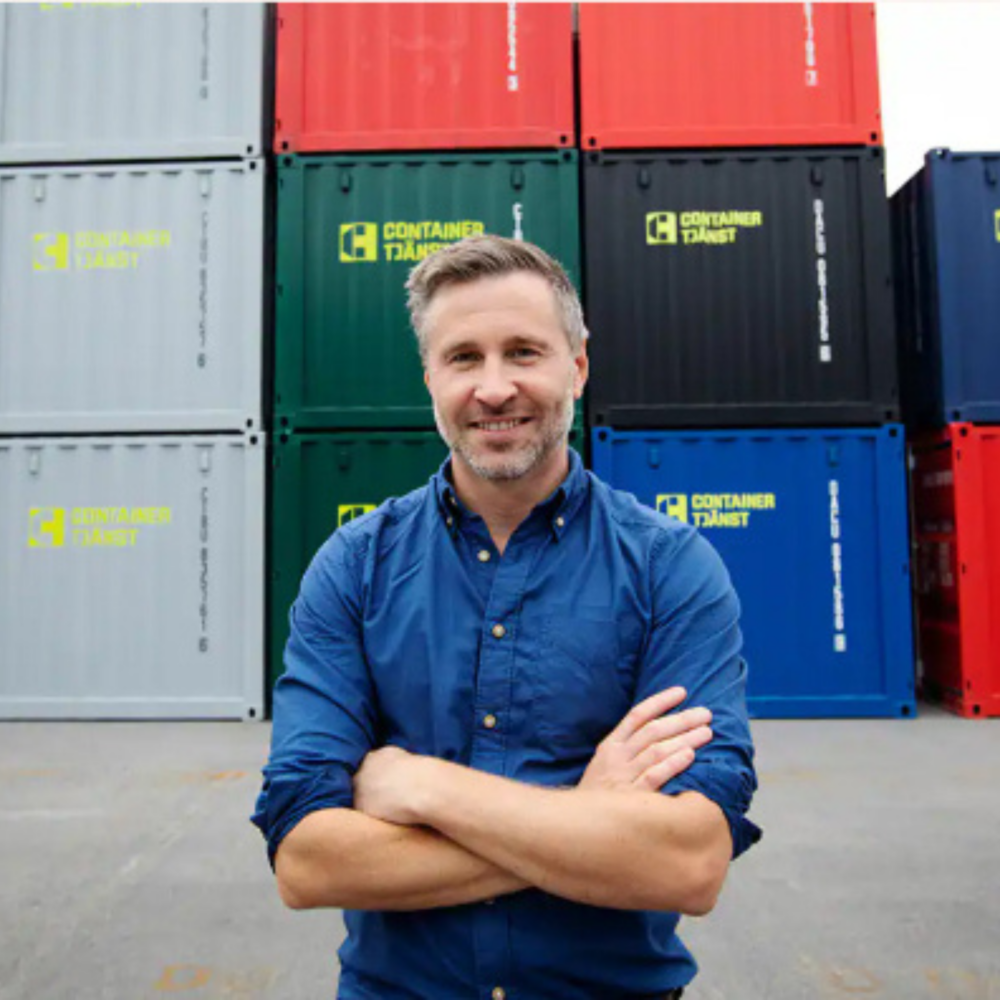 Containrar i olika färger och Thomas Johansson vd på Containertjänst i förgrunden